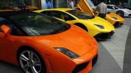 Men look at a Lamborghini car outside a showroom in Singapore's central business district.